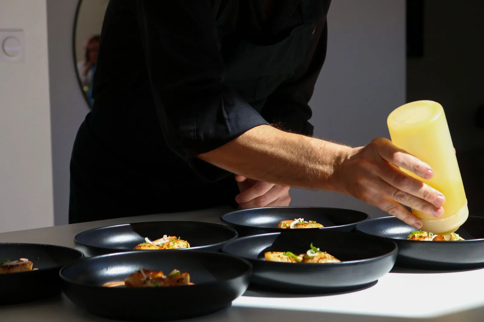Le Chef Jean-Philippe Bourgeois dressant des assiettes gastronomiques de Saint-Jacques